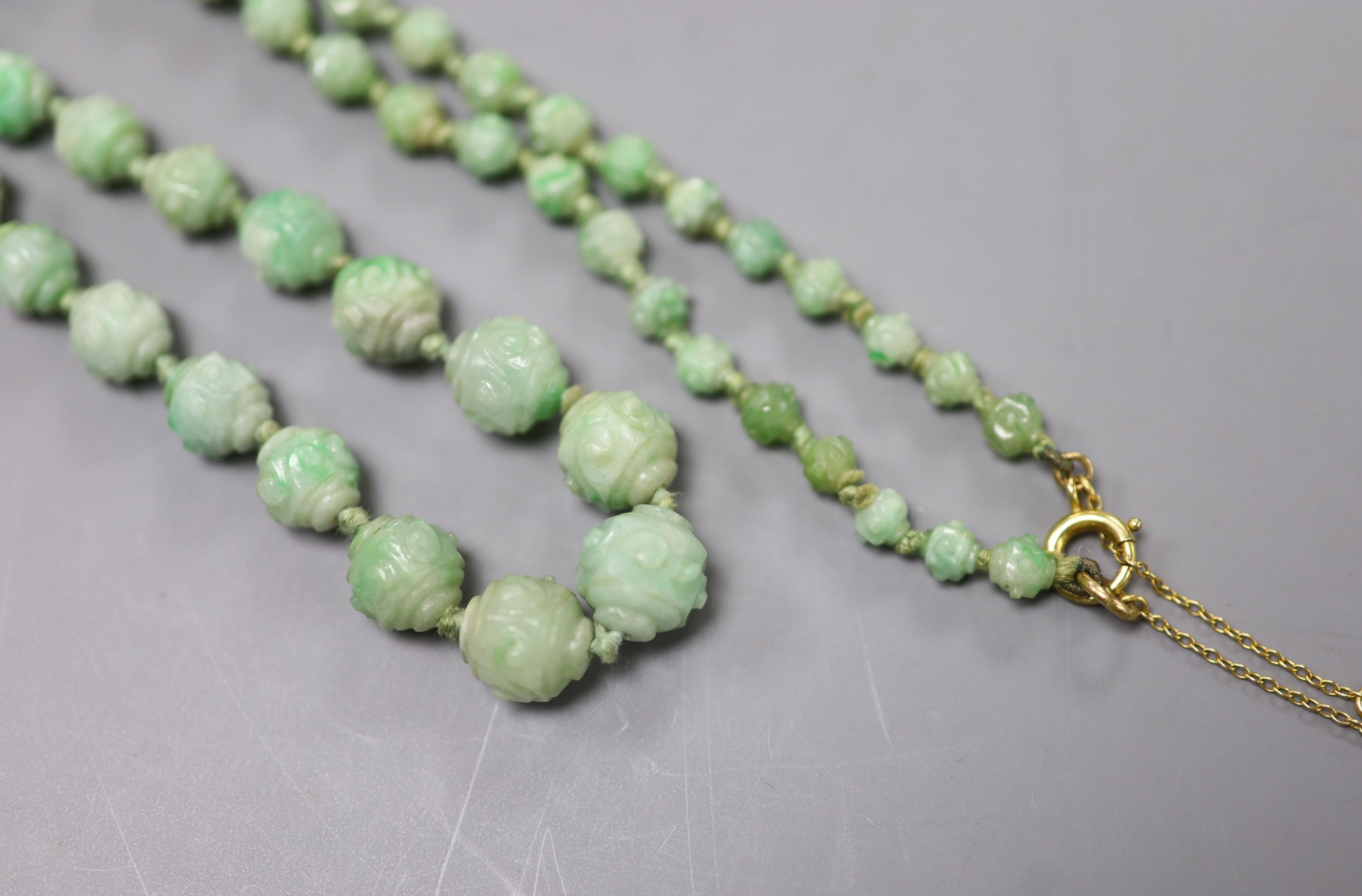 An early 20th century graduated carved jade bead necklace, with 9ct clasp, 47cm, gross weight 30 grams.